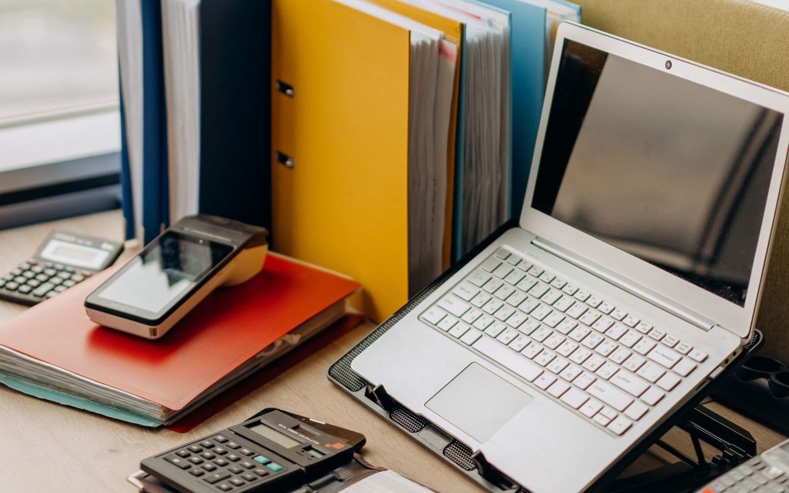 Classeurs de documents à côté d'un ordinateur portable sur un bureau